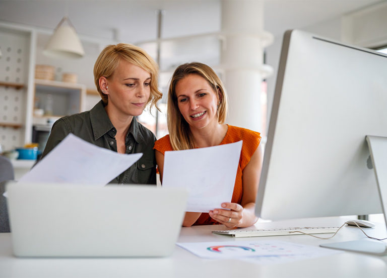 two women discussing marketing reports