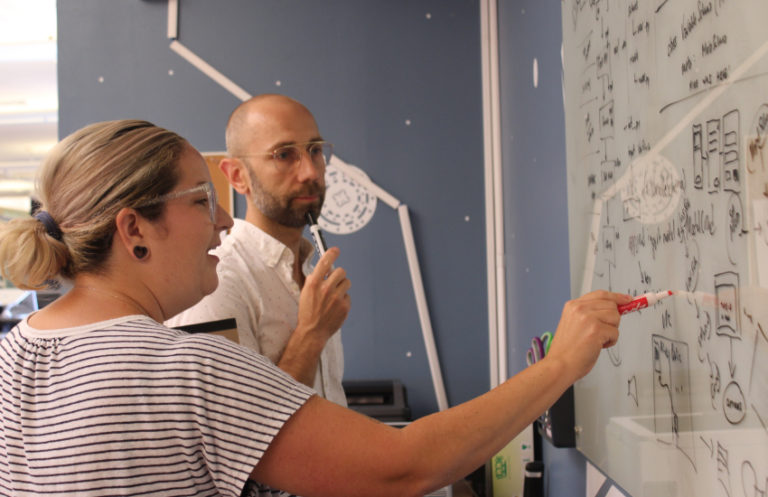 arcweb employees reviewing ui design on whiteboard